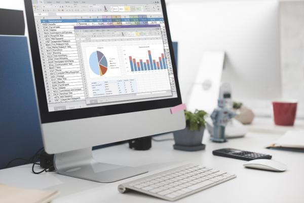 financial charts on computer screen sitting on desk