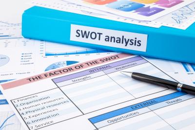 SWOT Analysis binder and paperwork on desk with pen